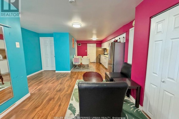 Living area with colorful walls, doorways, kitchen area, and dining table. - Lower Level - 6 Elmhurst Drive, Toronto