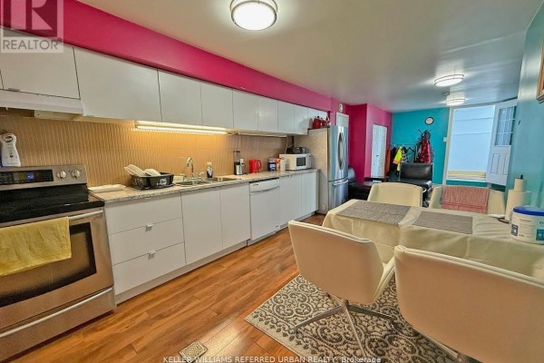 Kitchen with white cabinets, granite countertops, stainless steel appliances, and dining area. - Lower Level - 6 Elmhurst Drive, Toronto