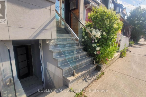 View of exterior stairs leading to a townhouse entrance with greenery. - Lower Level - 623 Dupont Street, Toronto