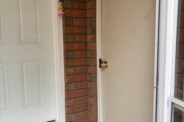 Close-up view of a brick column between two doors, one white and one beige. - Lower Level - Bsmnt Only - 5243 Heatherleigh Avenue, Mississauga