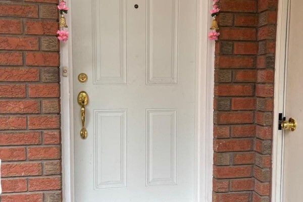 Front entrance with a white paneled door, brass handle, and decorative pink garlands. - Lower Level - Bsmnt Only - 5243 Heatherleigh Avenue, Mississauga