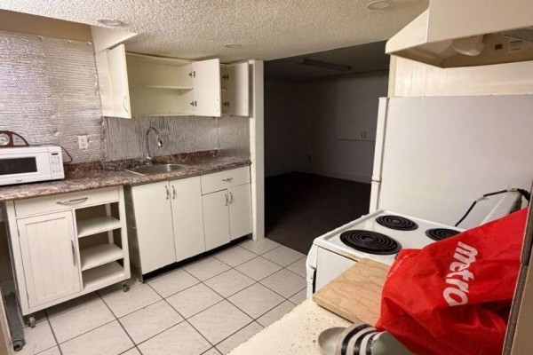 Bathroom with a white tub, toilet, vanity, tiled walls, and a shower curtain. - Lower Level B - 7 Waltham Drive, Toronto