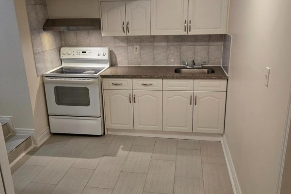 Compact basement kitchen with white cabinets, white stove, and granite countertop. - Lower Unit - 57 Mentor Boulevard, Toronto