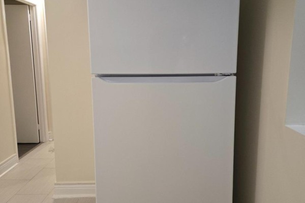 White refrigerator in a basement hallway with tiled floor and off-white walls. - Lower Unit - 57 Mentor Boulevard, Toronto