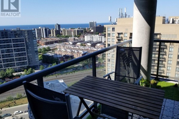 Balcony with a small table, chairs, and a view of the city and lake Ontario. - Lp-09 - 68 Abell Street, Toronto