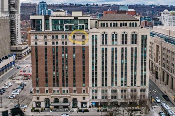Close-up exterior view of a brick building with modern glass additions and arched windows. - Lph01 - 112 King Street E, Hamilton