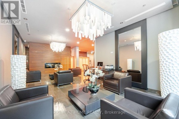 Lobby seating area with fireplace and wood-paneled wall accents. - Lph01 - 21 Nelson Street, Toronto