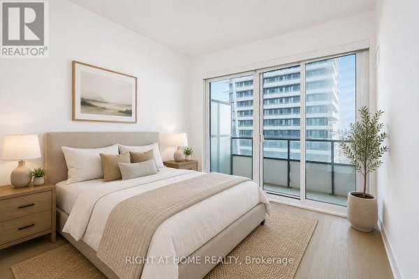 Modern white kitchen with stainless steel appliances, light wood flooring, and doorway. - Lph02b - 20 Shore Breeze Drive, Toronto
