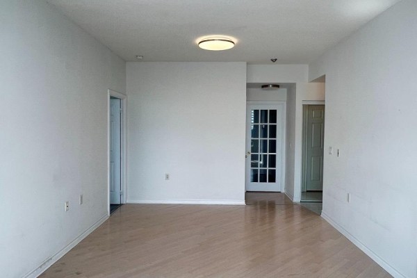Living area with light wood floors, white walls, and ceiling light fixture. - Lph17 - 2627 Mccowan Road, Toronto