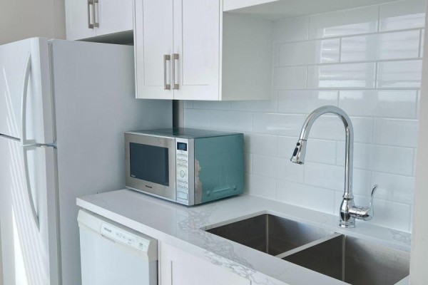 Kitchenette with white cabinets, subway tile backsplash, and stainless steel sink. - Lph17 - 2627 Mccowan Road, Toronto