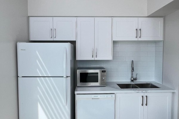 Kitchen with white cabinets, refrigerator, microwave, dishwasher, and subway tile backsplash. - Lph17 - 2627 Mccowan Road, Toronto