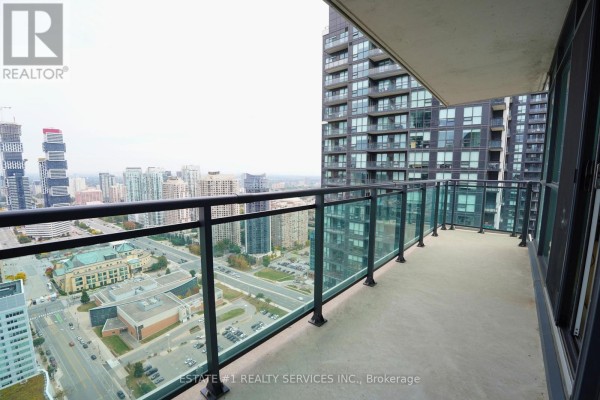 Spacious balcony with glass railings offering panoramic city views from a high floor. - Lph2 - 4065 Brickstone Mews, Mississauga