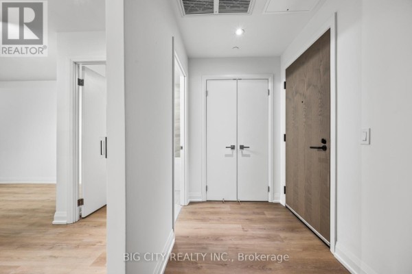 Building lobby with a marble reception desk, two armchairs, and a round coffee table. - M04 - 36 Brentcliffe Road, Toronto