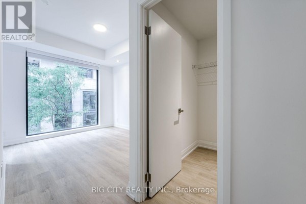 Open doorway reveals a closet with wire shelving. Bedroom is visible beyond. - M05 - 36 Brentcliffe Road, Toronto