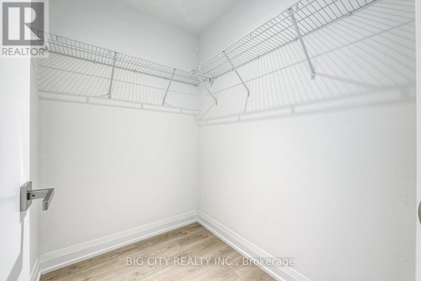 Empty walk-in closet with white wire shelving and light wood flooring. - M05 - 36 Brentcliffe Road, Toronto