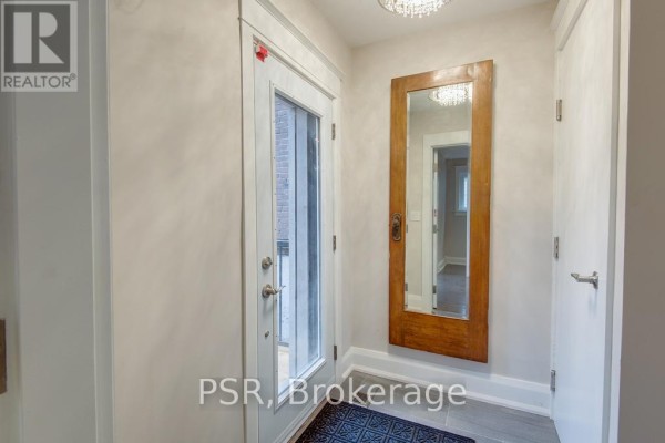 Interior entryway with a glass door, large wooden mirror, and light grey walls. - Main - 109 Neville Park Boulevard, Toronto