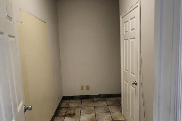 Interior view of a small room with tiled floor, two doors, and light-colored walls. - Main - 1155 Dundas Street W, Toronto