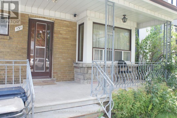Closer view of the porch with chairs and a table, featuring a brick and stone base. - Main - 131 Times Road, Toronto