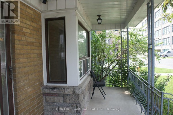 Side view of the porch showing a bay window and the street beyond. - Main - 131 Times Road, Toronto