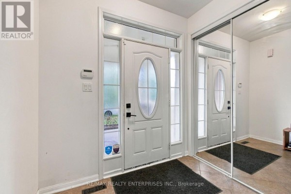 Foyer with white double doors, transom window, and full-length mirrored closet doors. - Main - 1765 Hayden Lane, Pickering