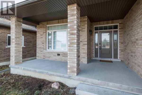View of the covered front porch with brick pillars and a large window to the left. - Main - 19 Bevan Drive, Belleville