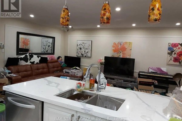 Open concept living area with a kitchen island, bar stools, and a large brown leather sectional. - Main - 211 Beechy Drive, Richmond Hill