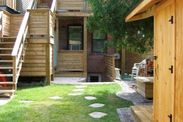 Backyard with a stone pathway, grass, wooden stairs, and a small shed. - Main - 226 Harvie Avenue, Toronto