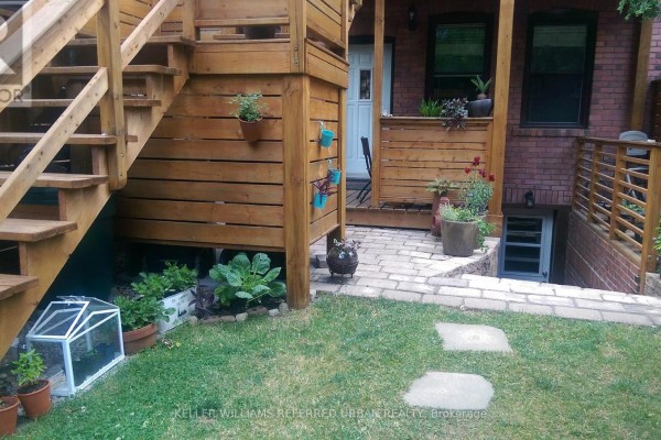 View of the backyard from the patio, showing stone path and plants. - Main - 226 Harvie Avenue, Toronto