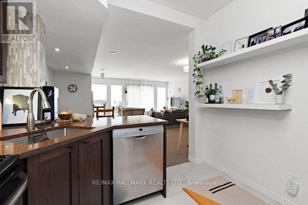 Kitchen island with granite countertop and stainless steel dishwasher, open to living area. - Main - 228 Pacific Avenue, Toronto