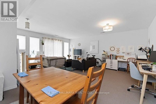 Open concept living and dining area with wooden table, sofas, and two desks. - Main - 228 Pacific Avenue, Toronto