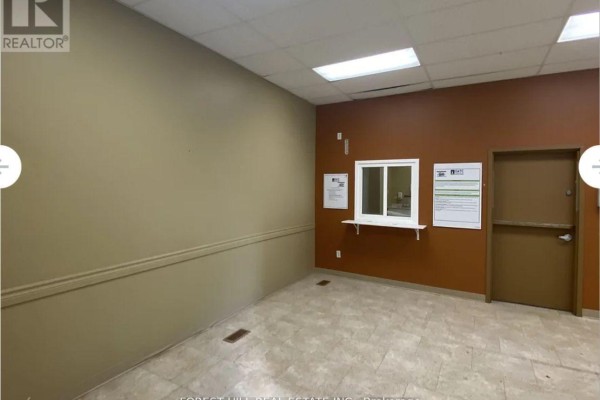 Interior commercial space with tan and rust-colored walls, a small window, and a door. - Main - 257 Front Street, Belleville