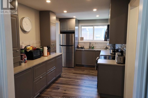 Kitchen with grey cabinetry, stainless steel appliances, a window, and light-colored countertops. - Main - 258 Carson Drive, Hamilton