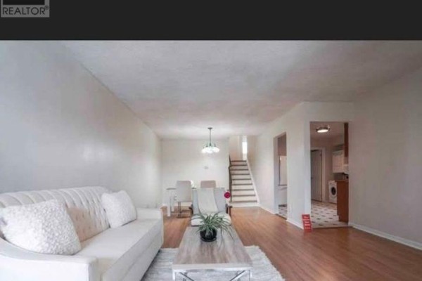 Living room with white walls, hardwood floors, and a sofa facing a coffee table. - Main - 26 Greenleaf Terrace, Toronto