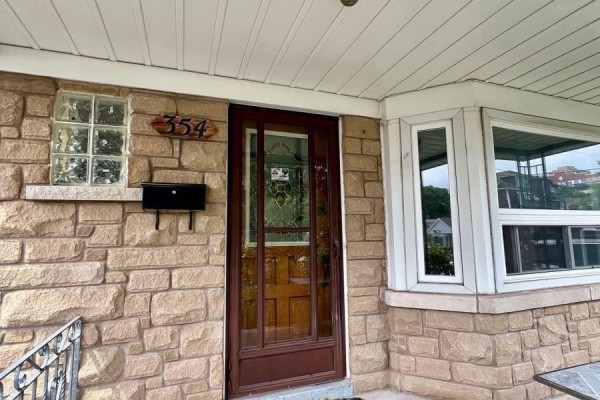 Close-up of the stone facade, front door, and mailbox of the house. - Main - 354 Kane Avenue, Toronto