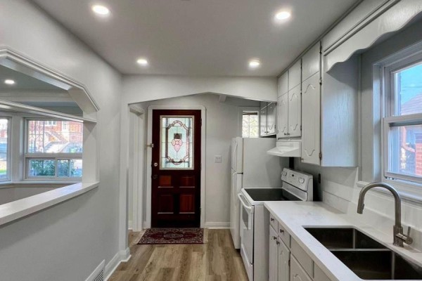 Interior view of a small kitchen with white cabinets, stainless steel sink, and appliances. - Main - 354 Kane Avenue, Toronto