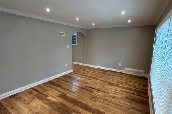 Living room with grey walls, hardwood floors, recessed lighting, and blinds on the window. - Main - 394 Whitmore Avenue, Toronto