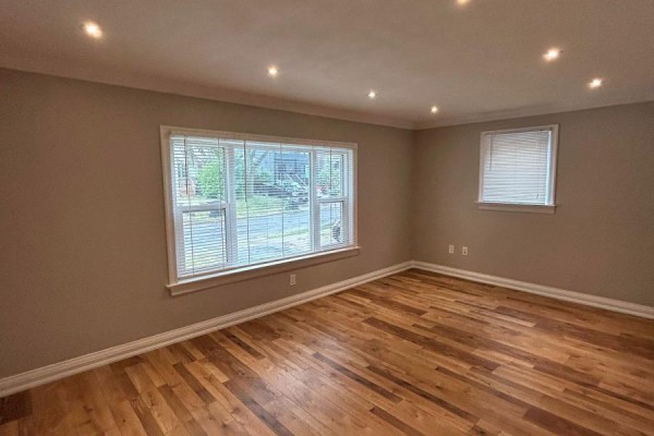 Room with grey walls, hardwood floors, recessed lighting, and two windows with blinds. - Main - 394 Whitmore Avenue, Toronto