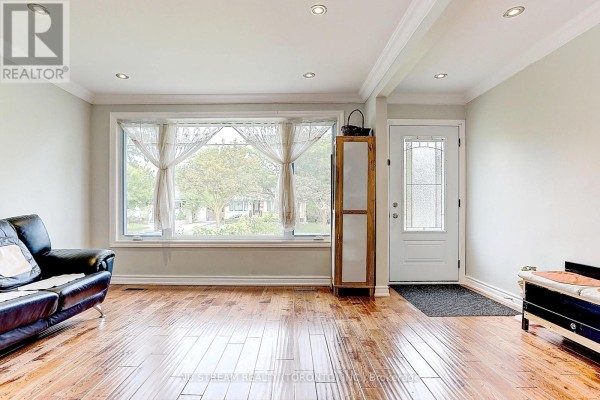 Living room with hardwood floors, a large bay window, and a black leather sofa. - Main - 432 Crosby Avenue, Richmond Hill