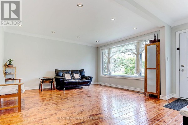 Spacious living room with hardwood floors, natural light from a large bay window, and furnished areas. - Main - 432 Crosby Avenue, Richmond Hill