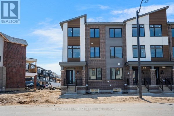 Street view of a townhouse complex featuring multi-level units with varied exterior materials. - Main - 50 Thornbird Crescent, Brampton