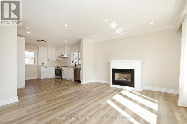 Open concept living room and kitchen with white cabinets and stainless steel appliances. - Main - 574 Olive Avenue, Oshawa