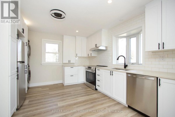White kitchen with stainless steel appliances, subway tile backsplash, and laminate flooring. - Main - 574 Olive Avenue, Oshawa