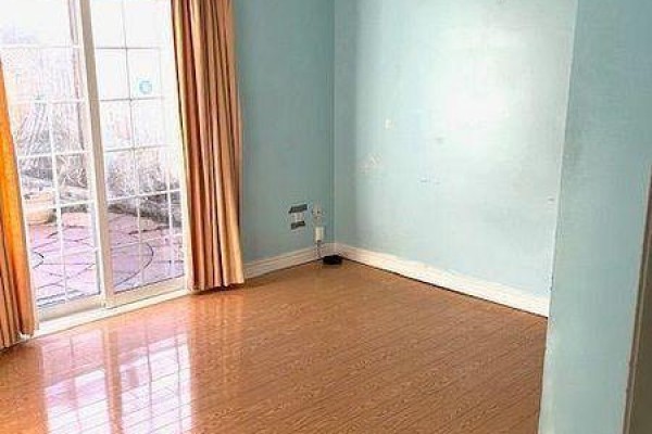 Room with light blue walls, wood floor, and a sliding glass door with orange curtains. - Main - 88 Wharnsby Drive, Toronto