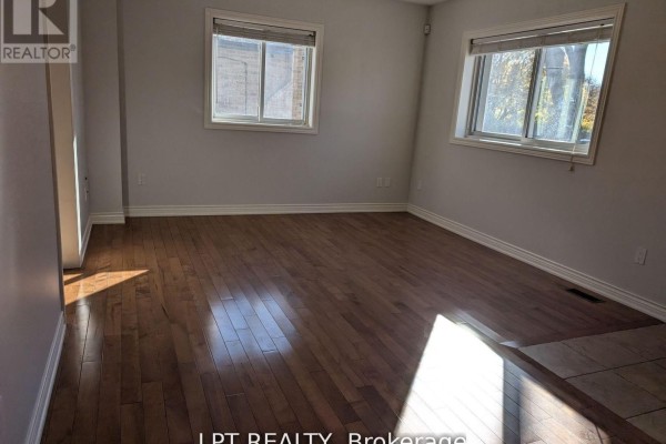 Bedroom with hardwood floors, beige walls, and two windows overlooking the neighborhood. - Main - 9 Atkinson Avenue, Toronto