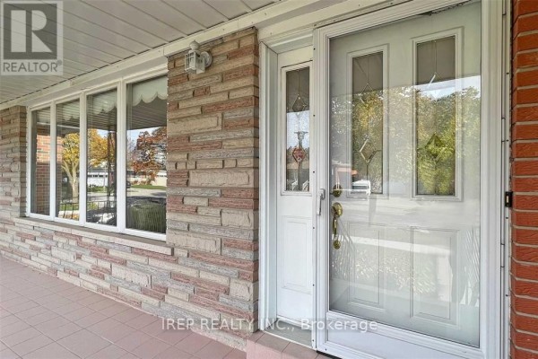 Close-up of the front entrance with a white door, glass panels, and decorative stone facade. - Main - 94 Iangrove Terrace, Toronto