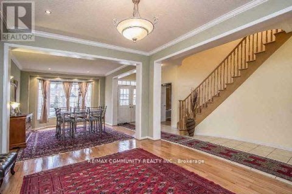 Foyer with a staircase, a dining area with a table, and hardwood floors. - Main Floor - 11 Horsetail Street, Markham