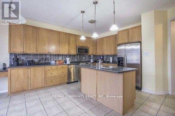 Kitchen with light wood cabinets, stainless steel appliances, a center island, and tile flooring. - Main Floor - 11 Horsetail Street, Markham