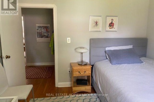Bedroom with a grey headboard, a single bed, and a wooden nightstand. - Main Floor - 1407 Kenmuir Avenue, Mississauga