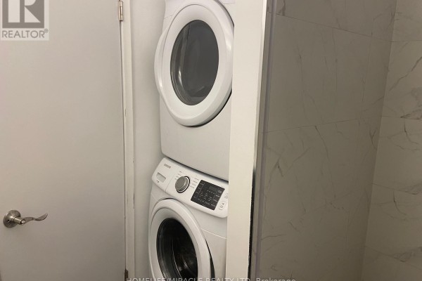 Stacked white Samsung washer and dryer in a small room with marble-patterned walls. - Main Floor - 25 Thornridge Crescent, Kitchener
