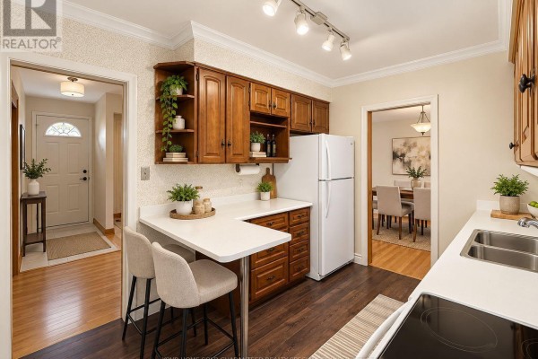 Kitchen with wood cabinets, white counters, and a view into the dining room. - Main Floor - 37 Downsview Drive, Barrie